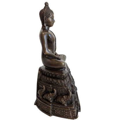 Side profile of Thai bronze meditation Buddha on tiered elephant pedestal