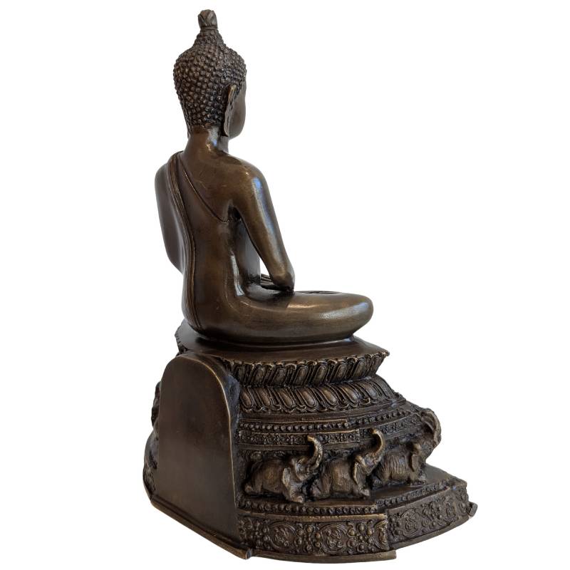 Three-quarter rear view showing the Buddha robe and elephant reliefs on the base