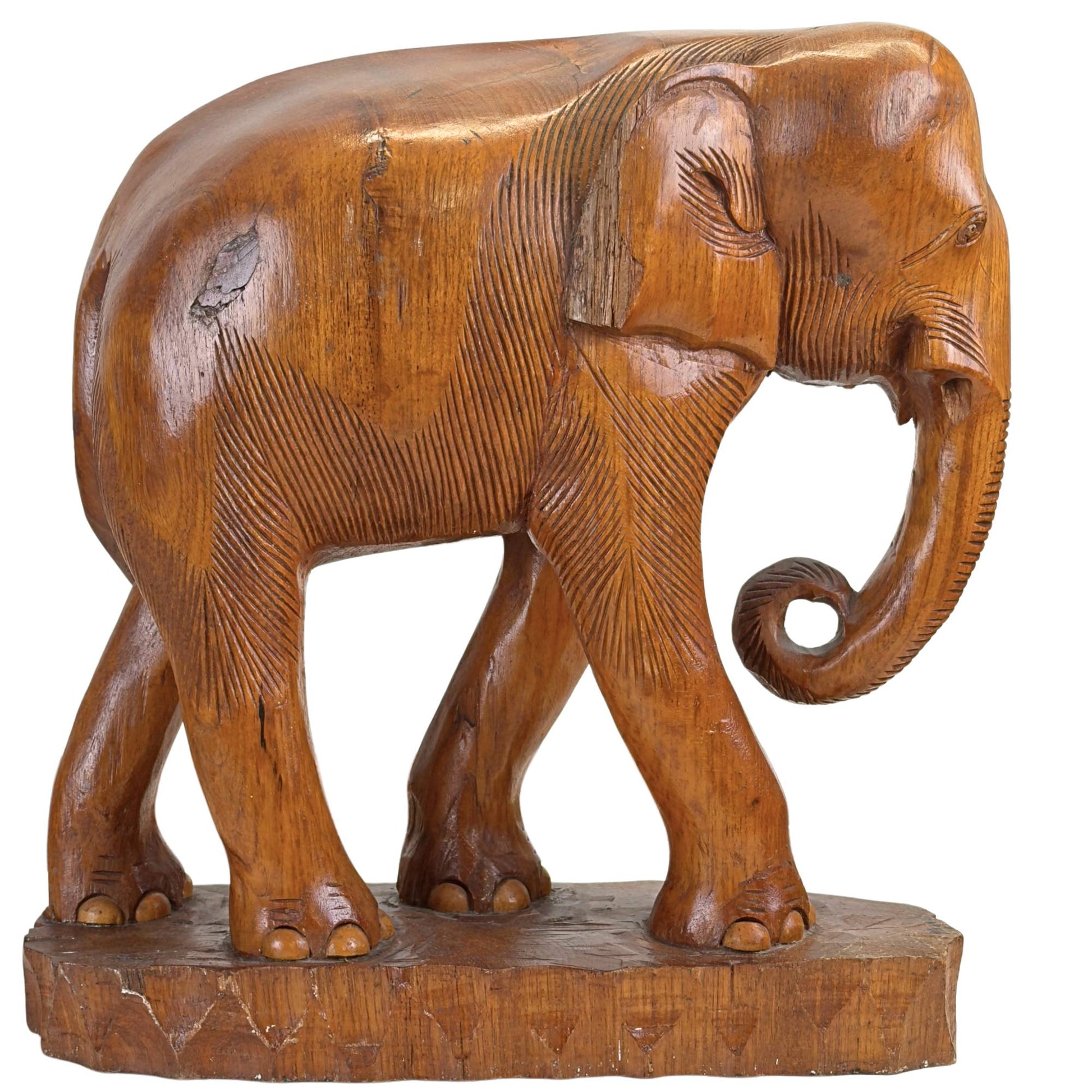 linkerzijde van de kleinste olifant, die de diepe, warme glans en de massieve volumewerking van het hout vangt.