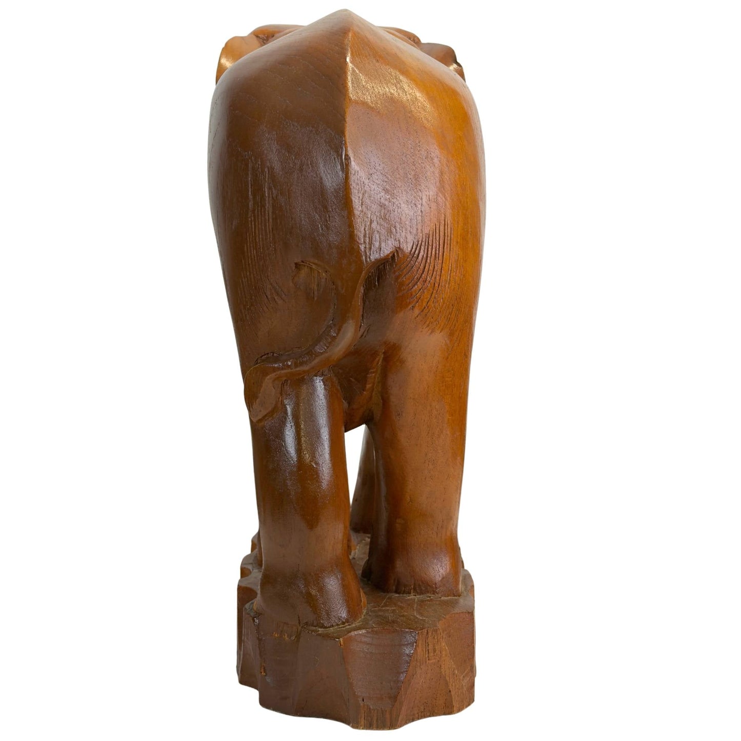 Direct achteraanzicht van het massieve olifantensculptuur met focus op de staart en de golvende textuur van de rugzijde.