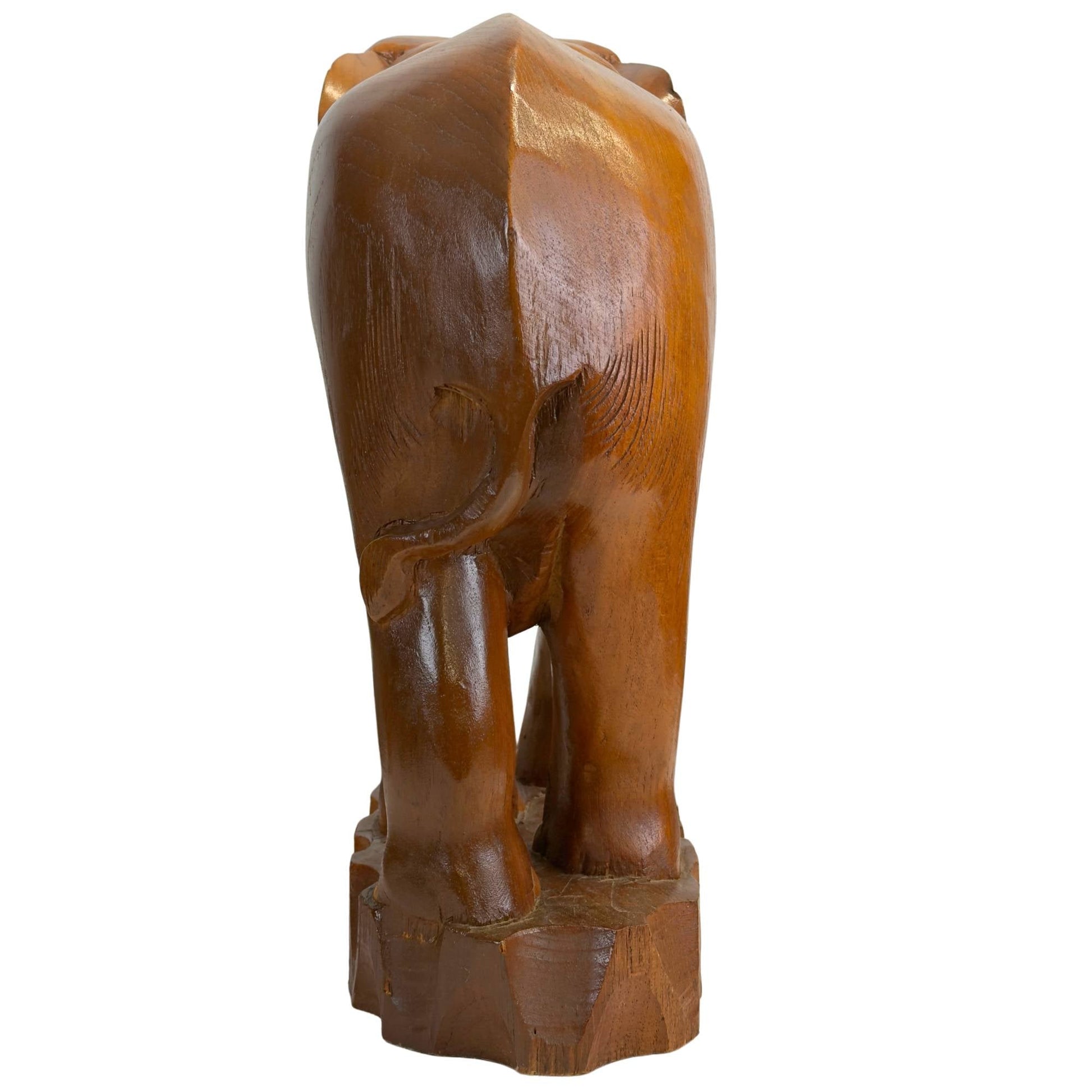 Direct achteraanzicht van het massieve olifantensculptuur met focus op de staart en de golvende textuur van de rugzijde.