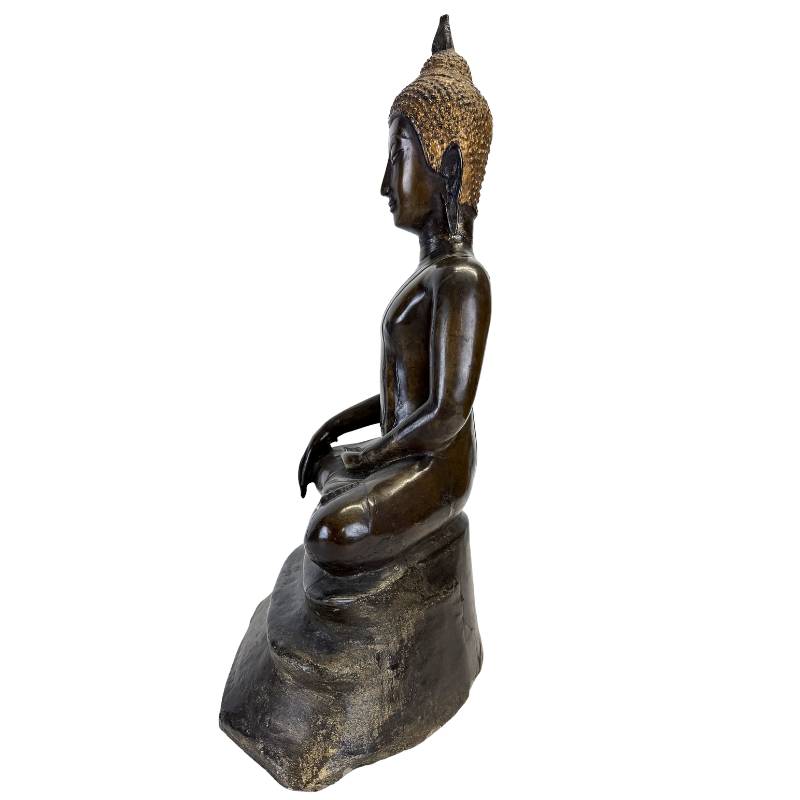 Side profile showing the Buddha’s elongated torso, seated posture and tiered polygonal base