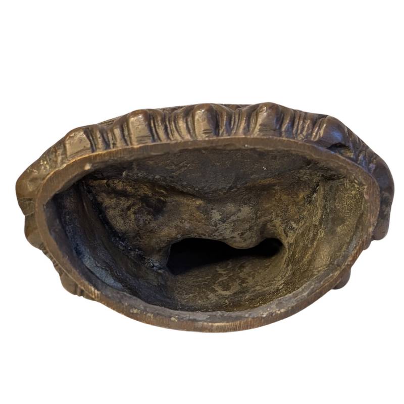 Open underside of bronze Buddha showing rough casting interior
