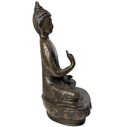 Right profile of seated bronze Buddha with raised hand in Vitarka Mudra