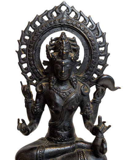 Close-up of bronze Vishnu showing the high crown, four arms, conch shell and openwork aureole