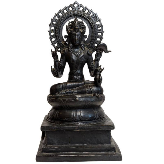 Front view of four-armed bronze Vishnu seated on a lotus base beneath an openwork aureole
