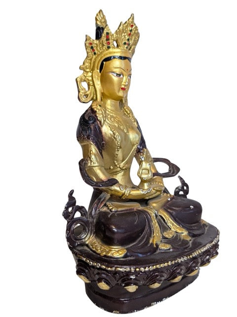 Gilded face and serene expression of the Tara