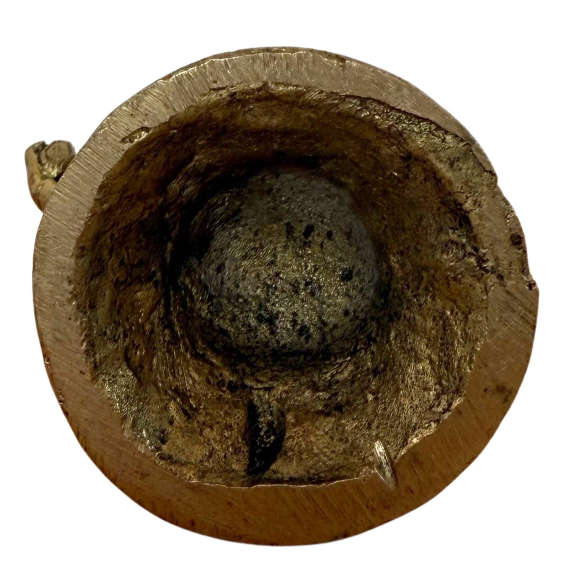 Forensisch detail van de onderzijde met de gemineraliseerde gietkern in de basis.