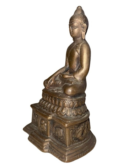 Oude bronzen Boeddha als collectiestuk met serene uitstraling en gedetailleerde basis