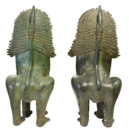Rear view of pair of bronze Singha temple lions showing manes and tails