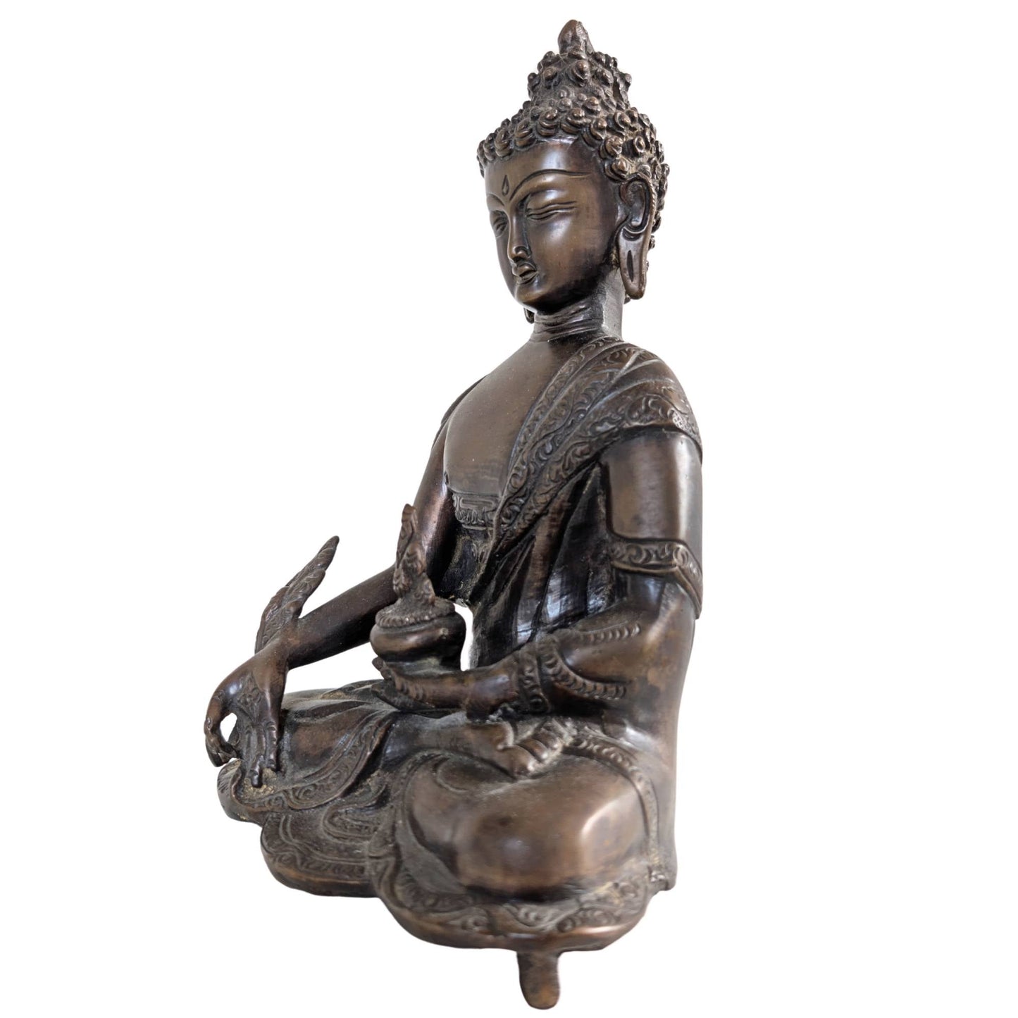 Profiel van de Medicijn Boeddha sculptuur met nadruk op de diepe patina.