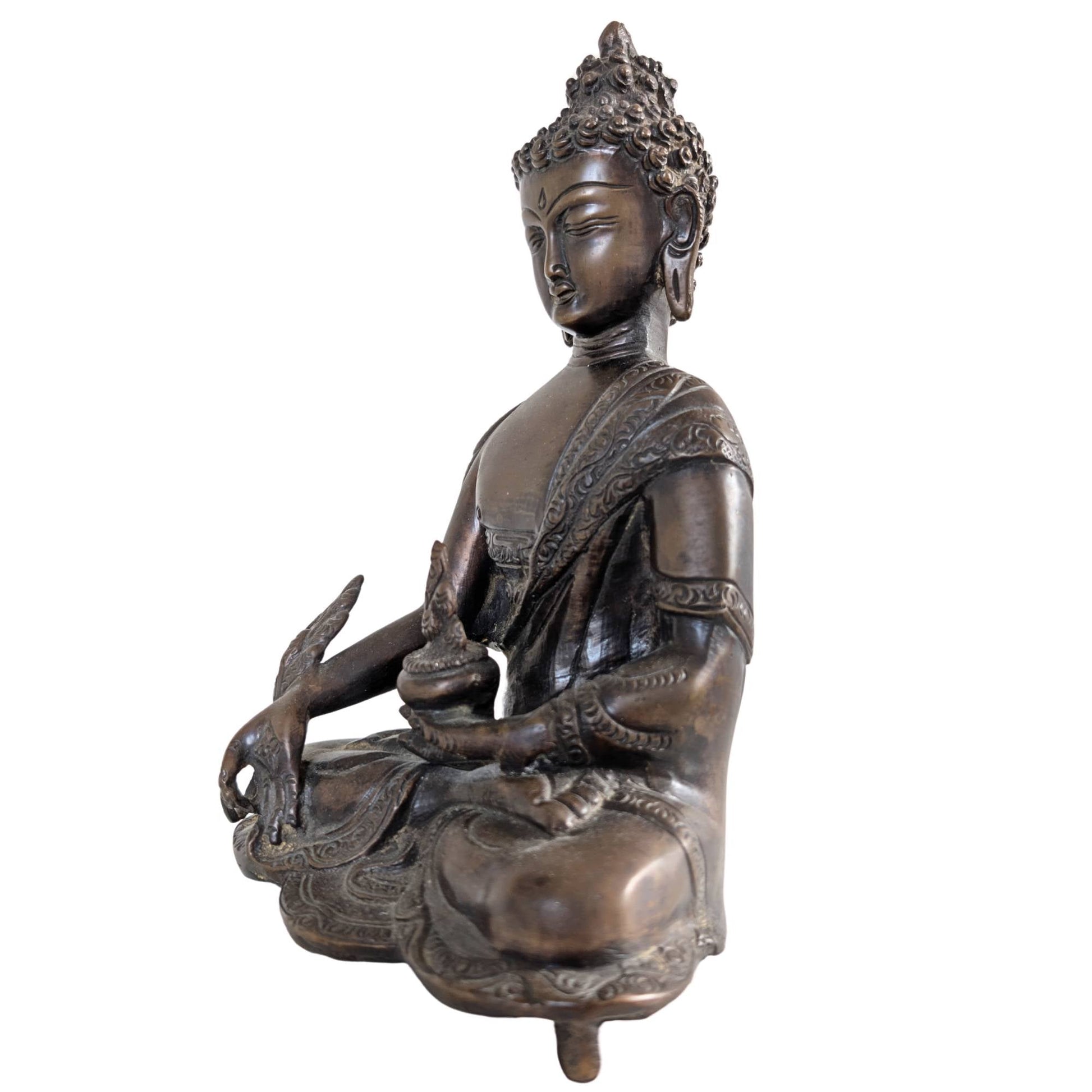 Profiel van de Medicijn Boeddha sculptuur met nadruk op de diepe patina.