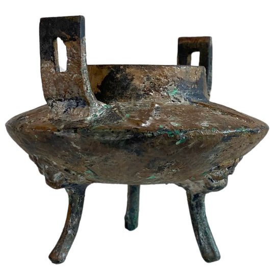 Zijaanzicht van het ijzeren offervat met zware minerale afzettingen en patina.