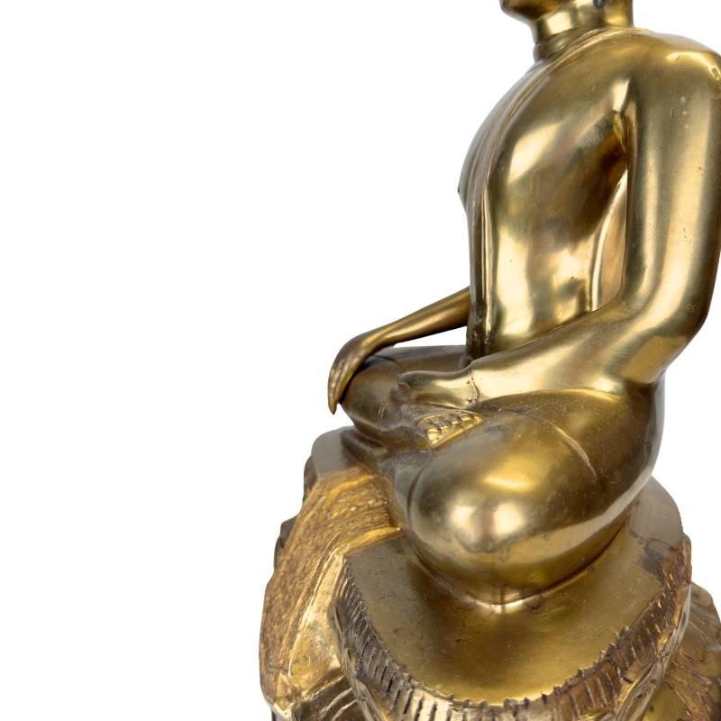 De verfijnde plooien van het sanghati (monniksgewaad) in zwaar gegoten brons.
