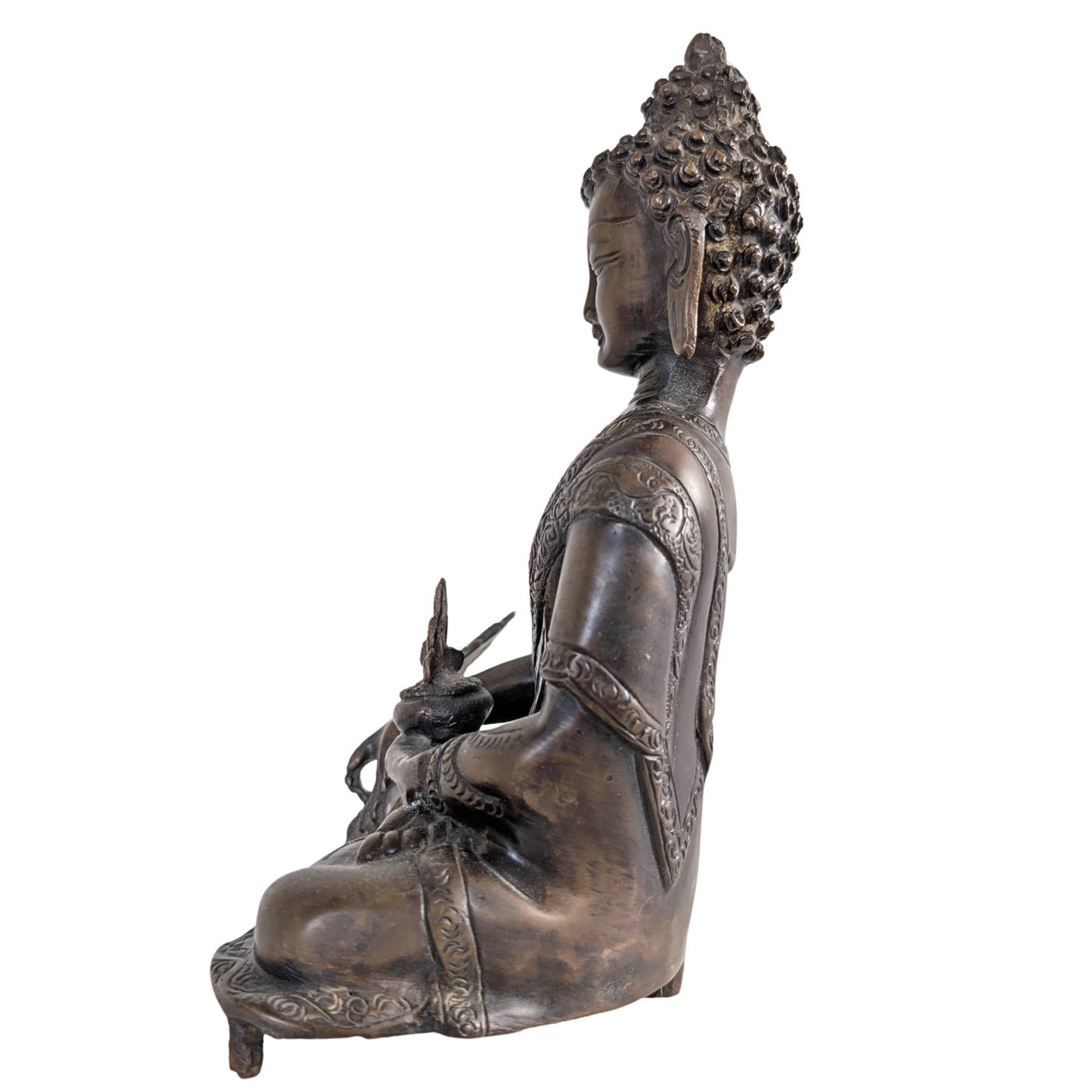 Close up van het serene gezicht en de traditionele haarknot op het bronzen beeld.