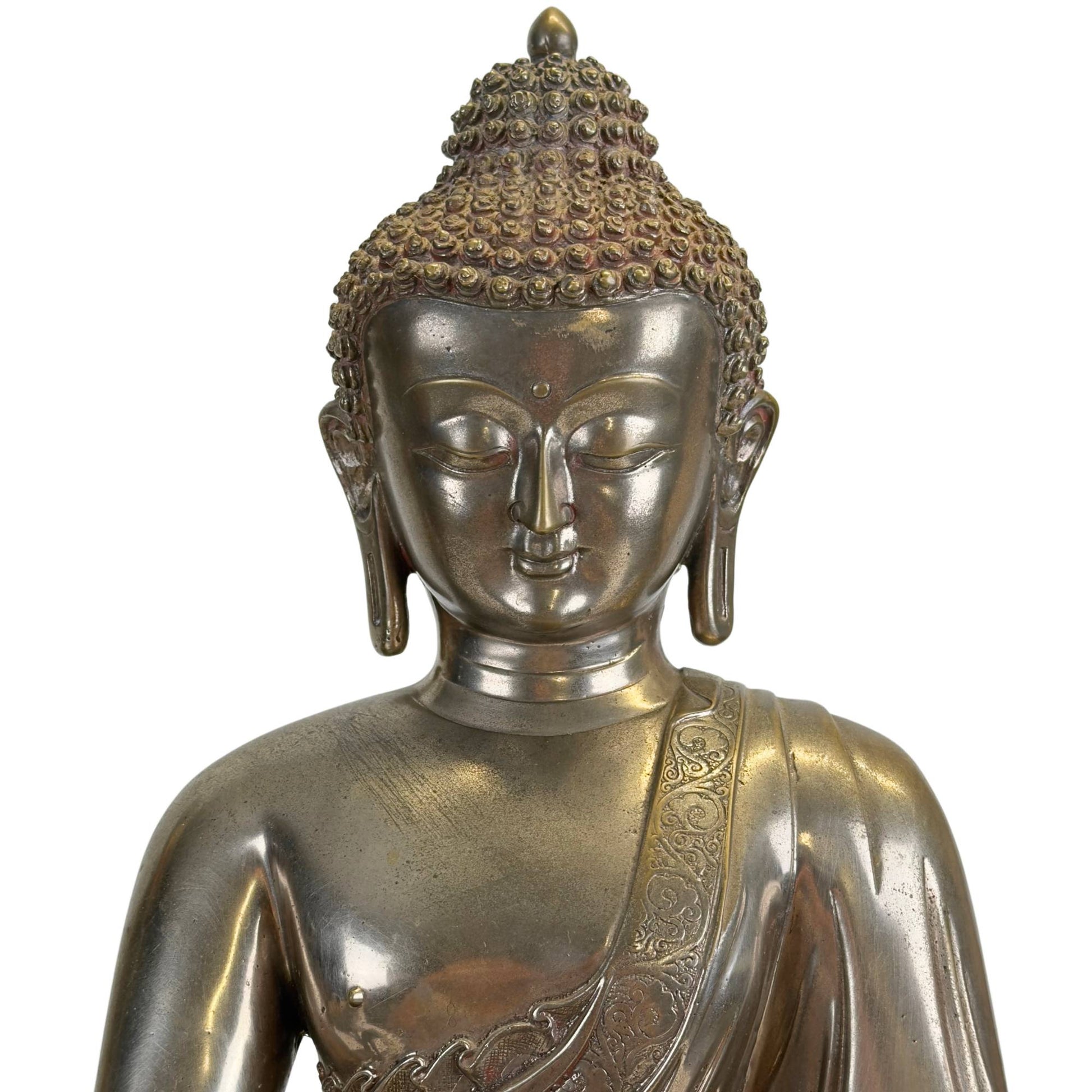 Face of the silvered Newar Medicine Buddha with urna, almond-shaped eyes and curled hair
