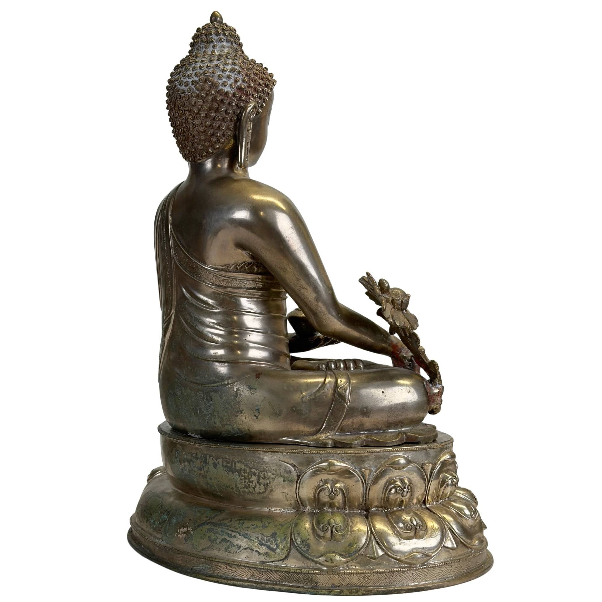 Silvered Newar Medicine Buddha with engraved robe and aged surface, rear three-quarter view