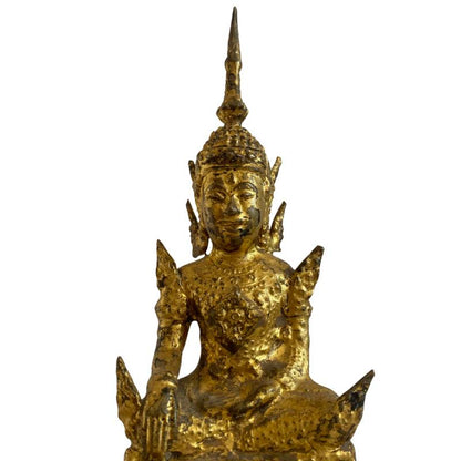 Close-up of the Buddha's face, gilded surface and earth-touching hand