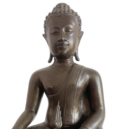 Detail of the Buddha's face without the flame finial, with the detached piece visible below