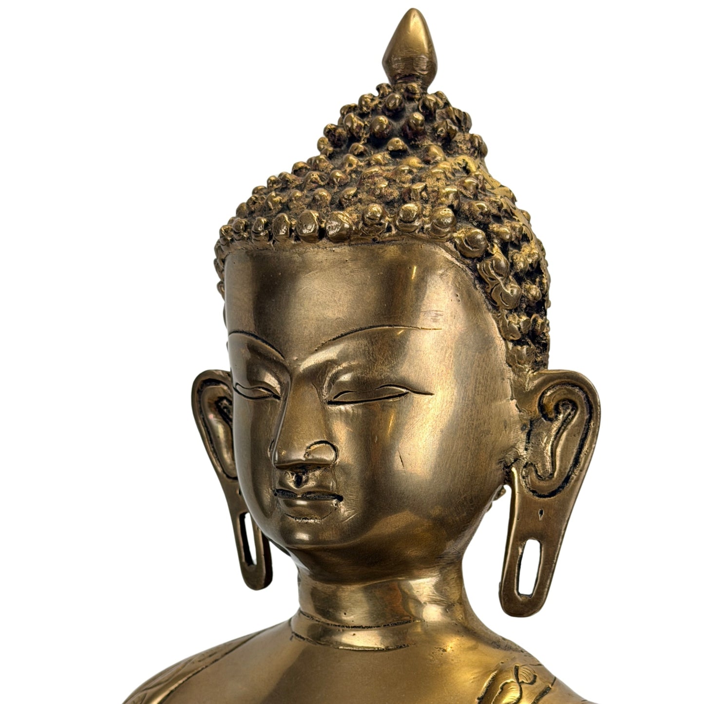 Facial detail of the Tibetan Shakyamuni Buddha with elongated earlobes