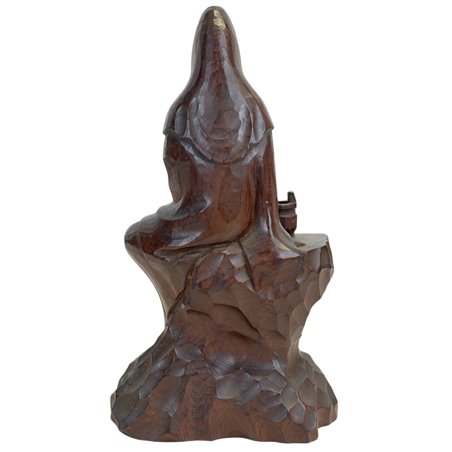 Volledig achteraanzicht van de boeddhistische sculptuur met de geometrische facet-beitelpaden op de rugzijde en de zachte glans op de hoofdkap.