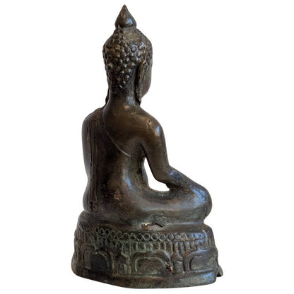 Rear-right view showing the Buddha's robe and aged bronze surface