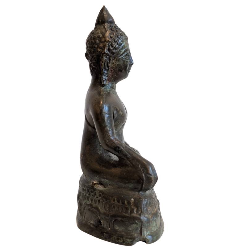 Right profile of the compact Thai bronze Buddha on its pedestal